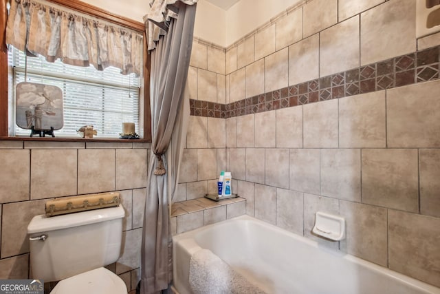 bathroom featuring toilet, tile walls, and shower / tub combo