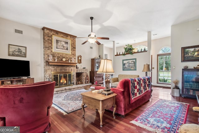 living room featuring ceiling fan, a fireplace, and hardwood / wood-style flooring