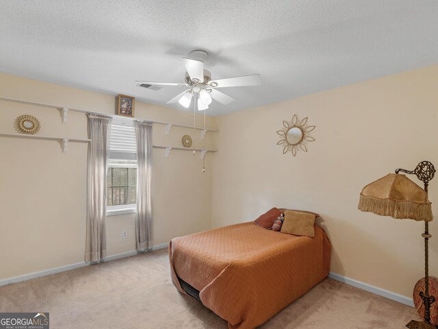 bedroom with light carpet, a textured ceiling, and ceiling fan