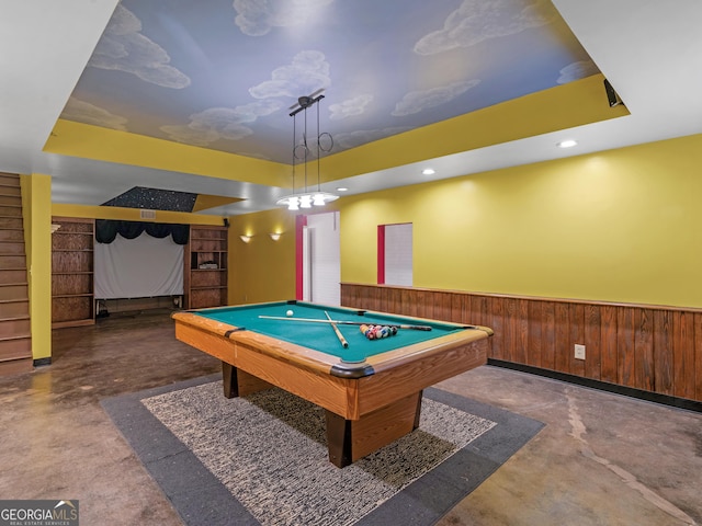 recreation room with a raised ceiling, concrete flooring, pool table, and wooden walls