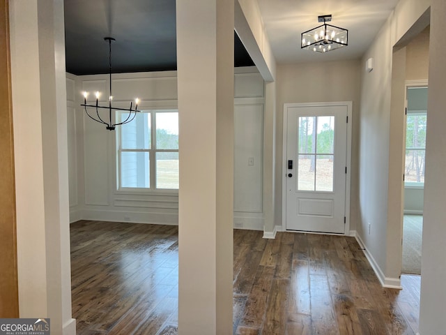 foyer featuring an inviting chandelier, dark wood-style floors, and a wealth of natural light