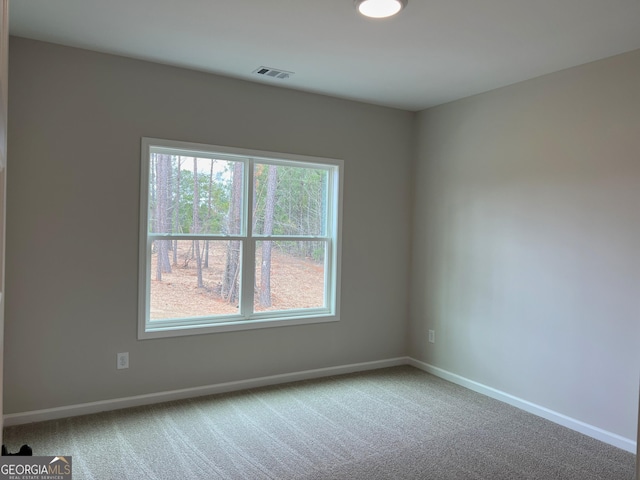 carpeted empty room featuring visible vents and baseboards