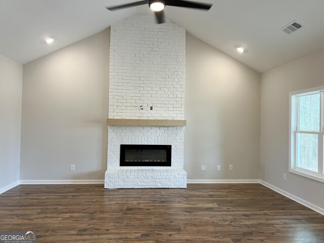unfurnished living room with dark wood finished floors, vaulted ceiling, visible vents, and a ceiling fan
