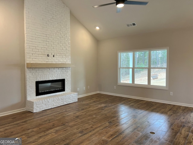 unfurnished living room with dark wood-style floors, a brick fireplace, visible vents, and ceiling fan