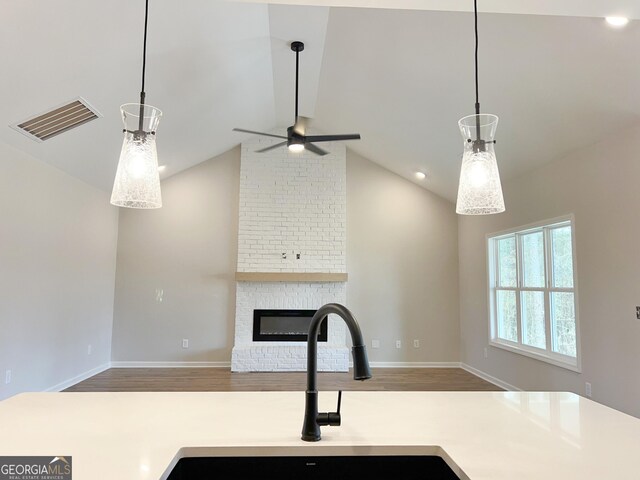 kitchen featuring light countertops, ceiling fan, vaulted ceiling, and visible vents