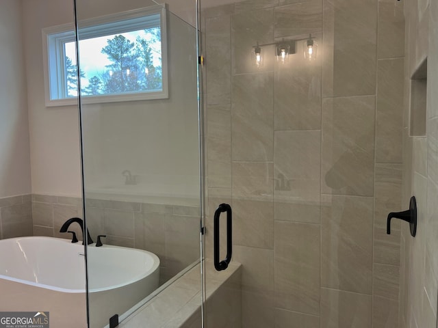 full bathroom featuring a freestanding tub and a stall shower