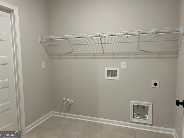 laundry area with laundry area, hookup for a washing machine, electric dryer hookup, and baseboards