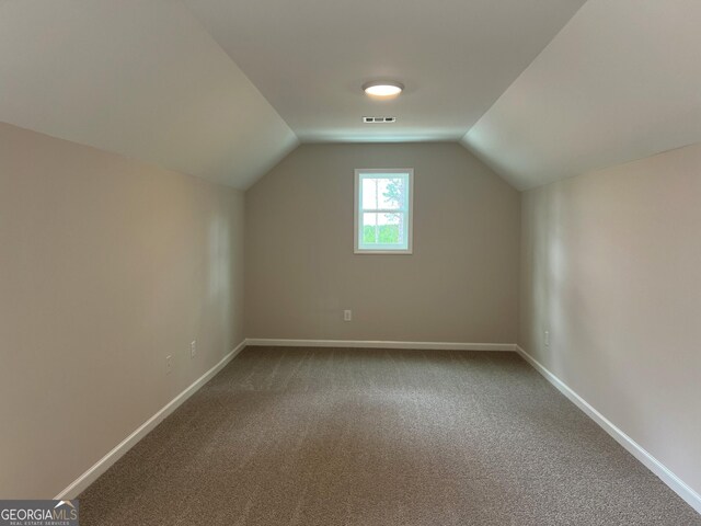 bonus room with baseboards, carpet, lofted ceiling, and visible vents