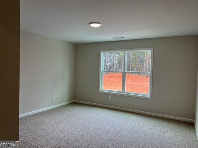 empty room featuring baseboards, visible vents, and carpet flooring