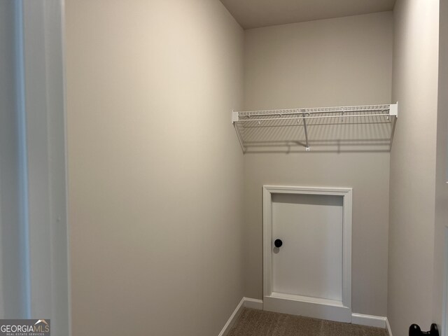 washroom featuring baseboards and dark colored carpet