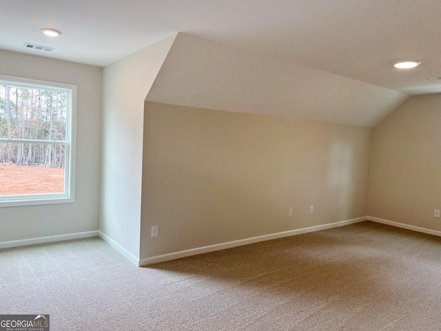 additional living space featuring vaulted ceiling, carpet, visible vents, and baseboards