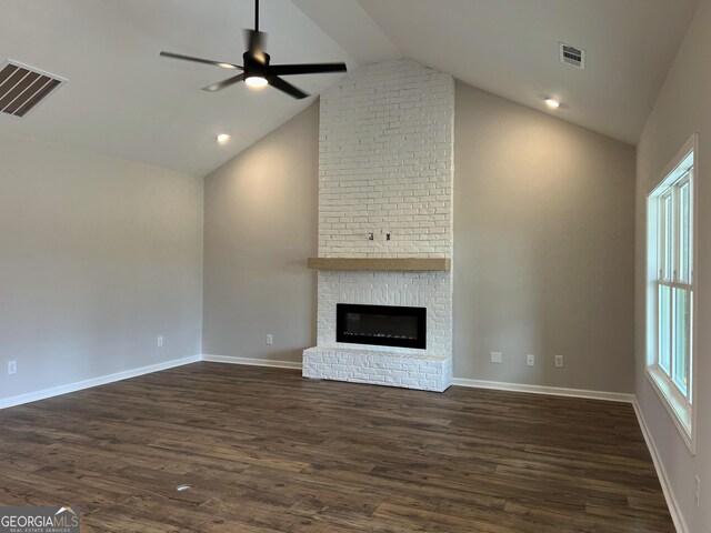 unfurnished living room with a brick fireplace, dark wood-type flooring, baseboards, and visible vents