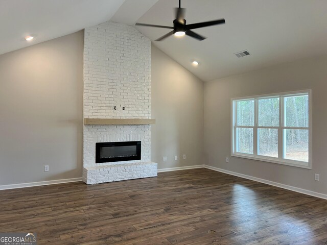 unfurnished living room with dark wood-style flooring, baseboards, ceiling fan, a brick fireplace, and visible vents