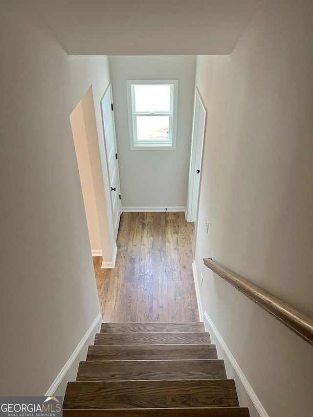 stairway featuring wood finished floors and baseboards