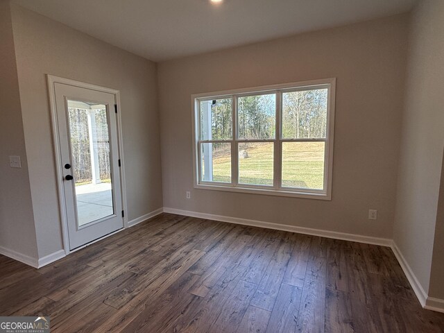 empty room with baseboards and dark wood-style flooring