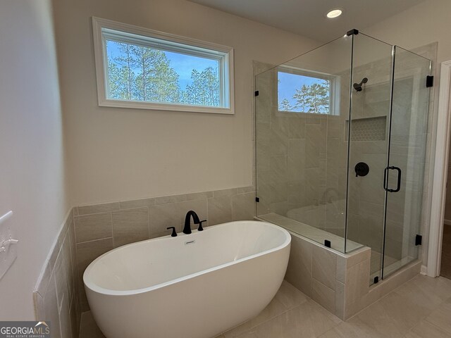 full bath featuring a freestanding tub, a stall shower, recessed lighting, and a healthy amount of sunlight