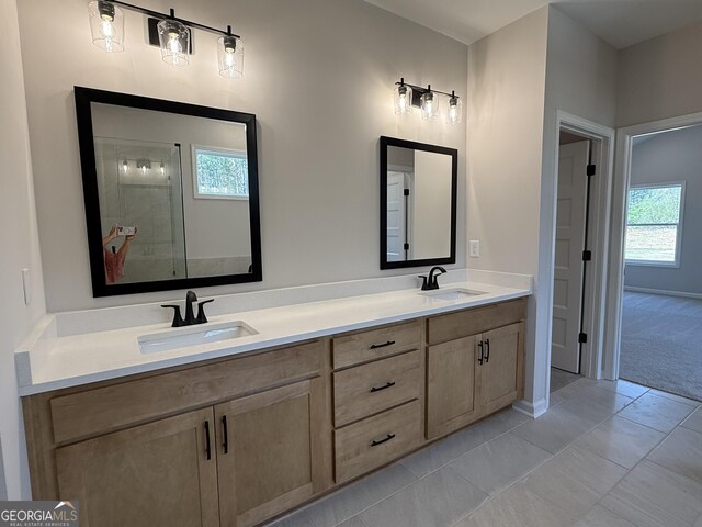 full bathroom with tile patterned floors, a tile shower, double vanity, and a sink