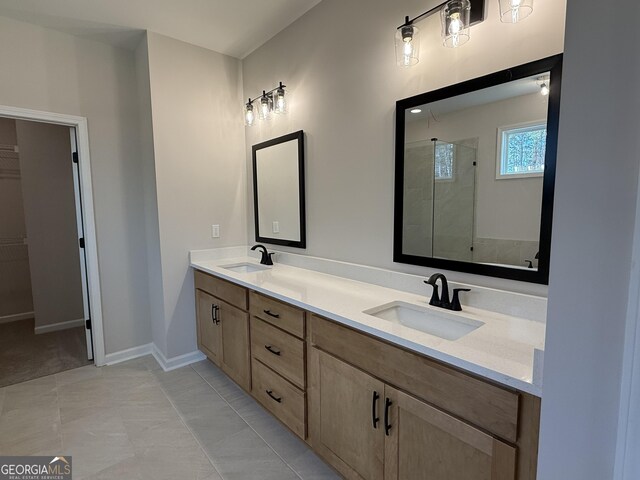 bathroom featuring double vanity, a sink, baseboards, and a shower stall