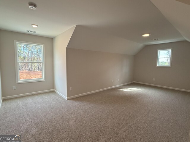 bonus room with baseboards, visible vents, lofted ceiling, and carpet floors