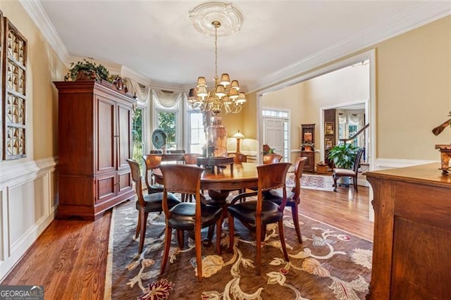 dining room featuring a chandelier, dark hardwood / wood-style floors, and crown molding