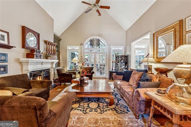 living room with wood-type flooring, high vaulted ceiling, and ceiling fan