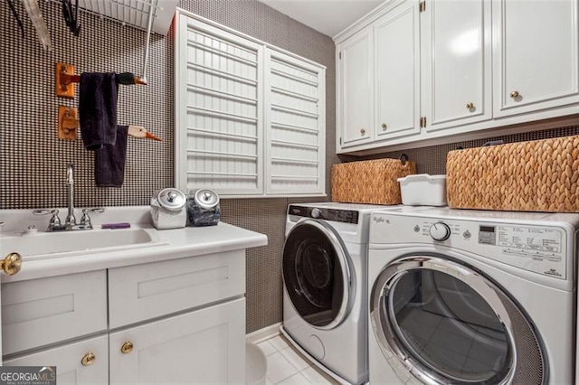 laundry room featuring cabinets, washing machine and dryer, light tile patterned flooring, and sink