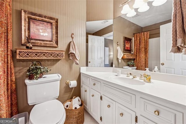 bathroom featuring tile patterned flooring, vanity, and toilet