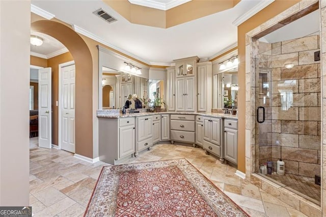 bathroom with vanity, crown molding, and a shower with shower door