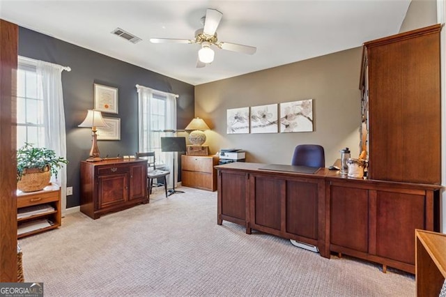 office with light colored carpet, ceiling fan, and a healthy amount of sunlight