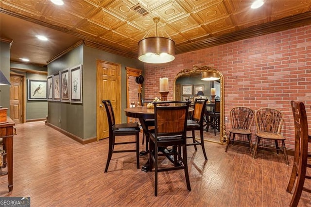 dining room with light hardwood / wood-style floors and brick wall