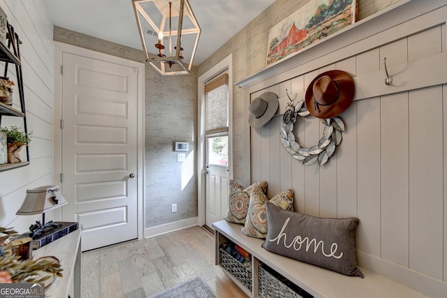 mudroom with wood walls and light hardwood / wood-style flooring