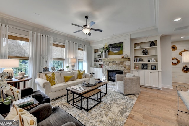 living room featuring a fireplace, built in features, plenty of natural light, and light hardwood / wood-style flooring