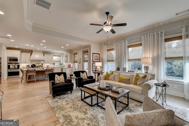 living room featuring ceiling fan, light hardwood / wood-style floors, and ornamental molding