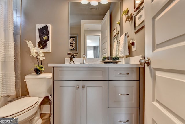 bathroom featuring a shower with curtain, vanity, and toilet