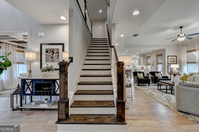 stairs with ceiling fan, coffered ceiling, beamed ceiling, crown molding, and hardwood / wood-style flooring