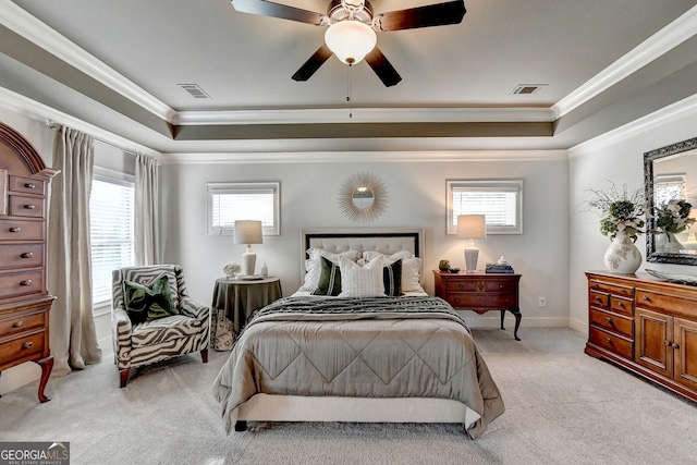 bedroom featuring multiple windows, light colored carpet, a raised ceiling, and ceiling fan