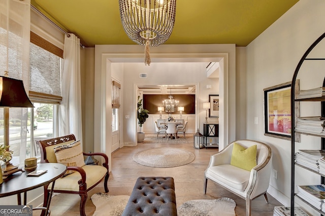 living area featuring light hardwood / wood-style flooring and an inviting chandelier