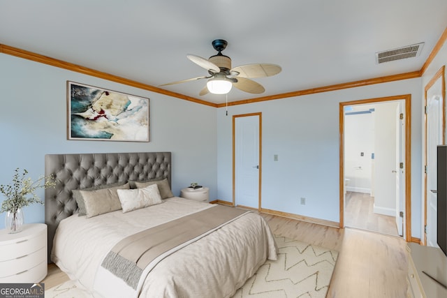 bedroom with ceiling fan, ensuite bath, light hardwood / wood-style floors, and crown molding