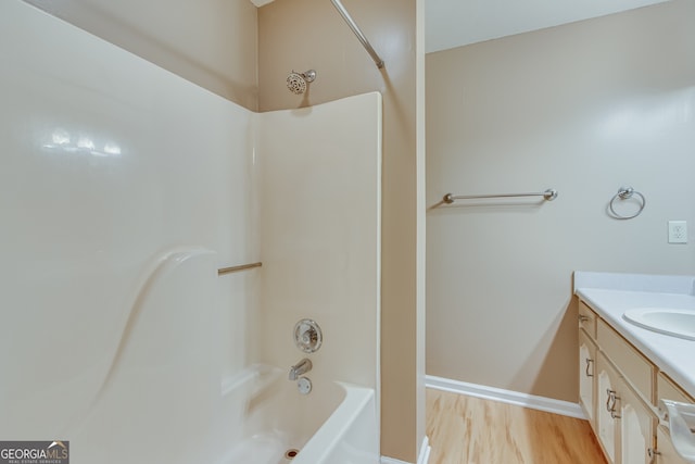 bathroom featuring vanity, hardwood / wood-style floors, and washtub / shower combination