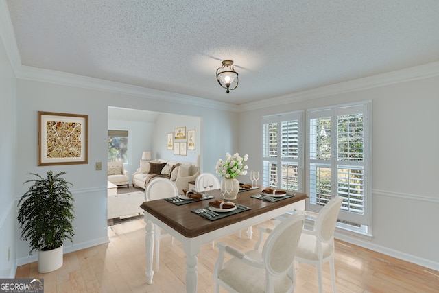 dining area with a textured ceiling, light hardwood / wood-style floors, and crown molding