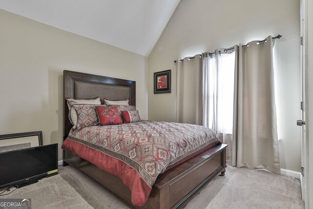 bedroom featuring light colored carpet and vaulted ceiling