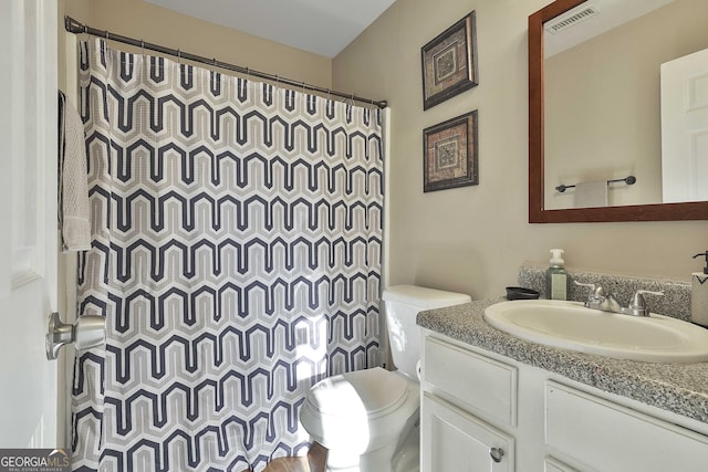 bathroom with vanity, toilet, and curtained shower