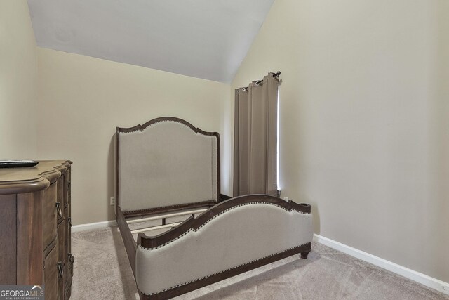 bedroom with light colored carpet and vaulted ceiling