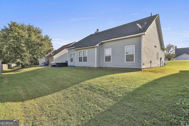 back of house featuring central AC and a yard