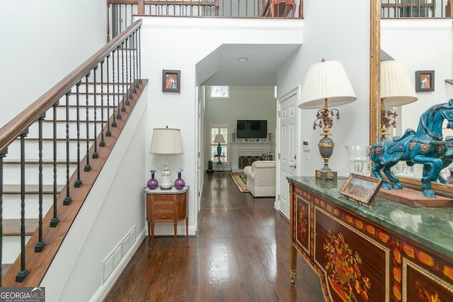 interior space with hardwood / wood-style floors and a towering ceiling