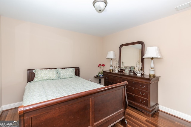 bedroom with dark hardwood / wood-style floors