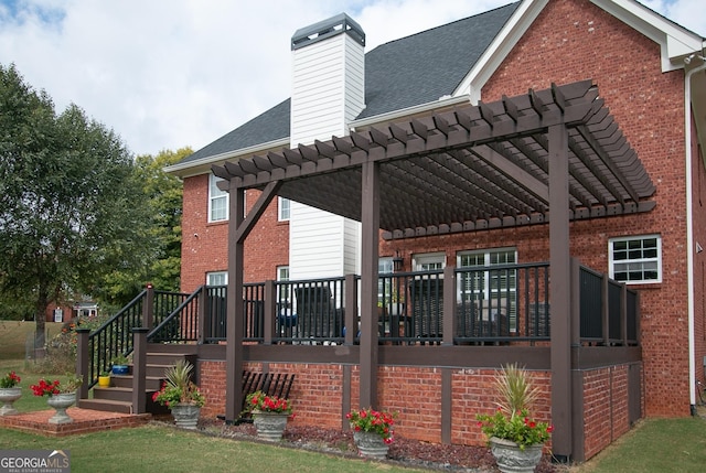 back of property featuring a pergola and a wooden deck