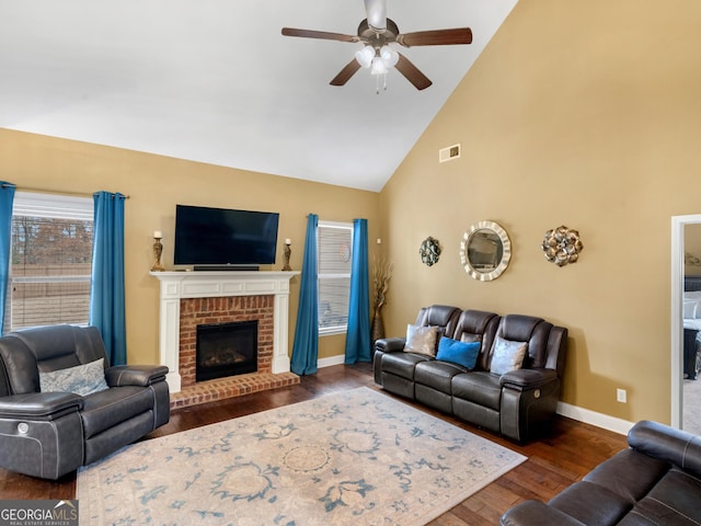 living room featuring ceiling fan, a fireplace, high vaulted ceiling, and dark hardwood / wood-style floors