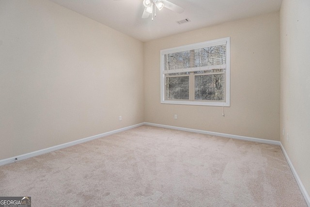 carpeted spare room with ceiling fan