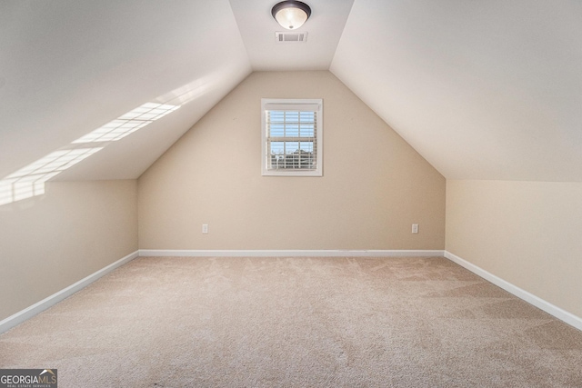 bonus room with carpet flooring and vaulted ceiling